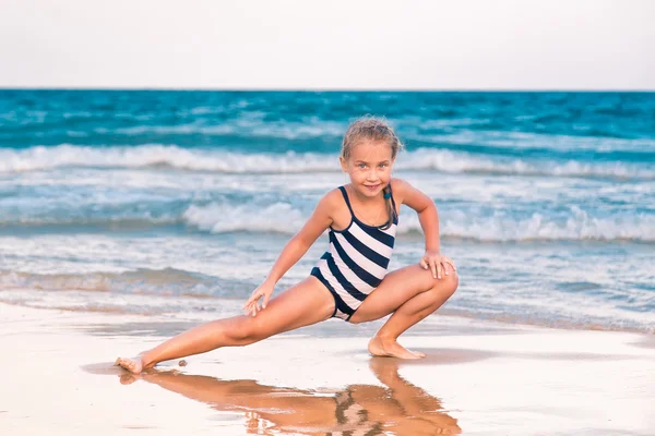 Hermosa niña haciendo ejercicio en la playa — Foto de Stock