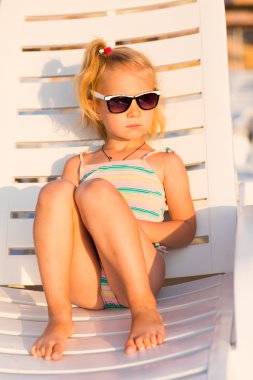 Adorable kid sunbathing on a beach