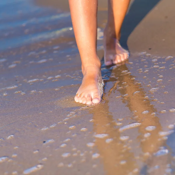 Child walking with bare feet along the seashore — Stock Photo, Image