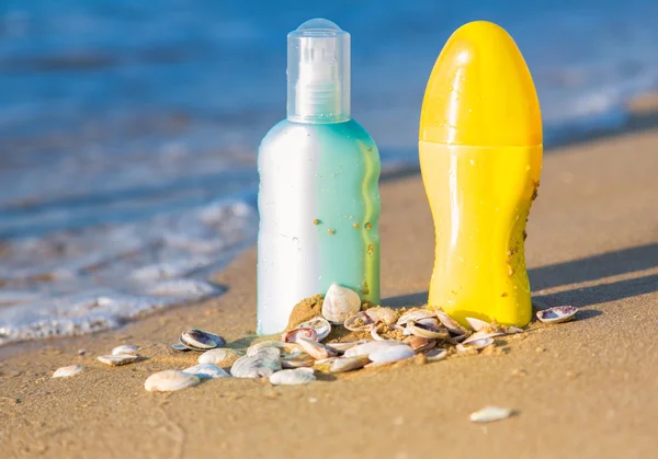 Sun protection creams on a seashore, sandy beach — Stock Photo, Image