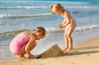 schattige meisjes spelen op de kust