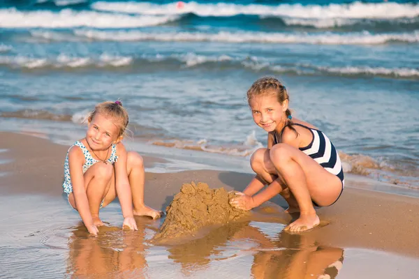 Schattige meisjes spelen op de kust — Stockfoto