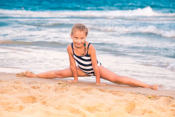 Krásná malá holka cvičení na pláži — Stock fotografie