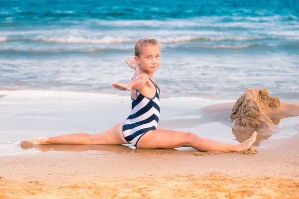 Belle petite fille excerçant sur la plage — Photo