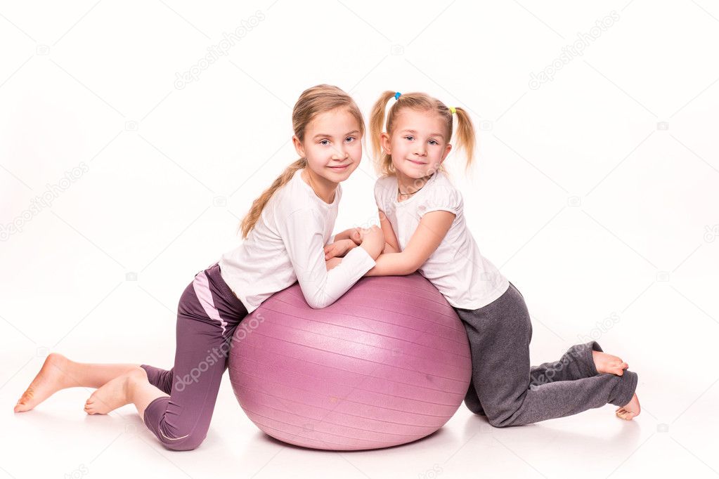 Sportive girls on a fit ball isolated over white