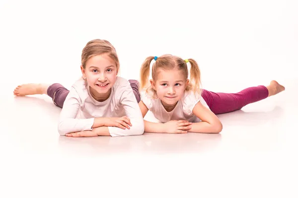 Sportive girls on a floor isolated over white — Stock Photo, Image