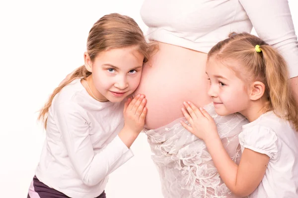 Boldog gyermekek, a terhes nő hasa gazdaság — Stock Fotó