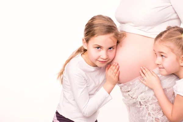 Crianças felizes segurando barriga de mulher grávida — Fotografia de Stock