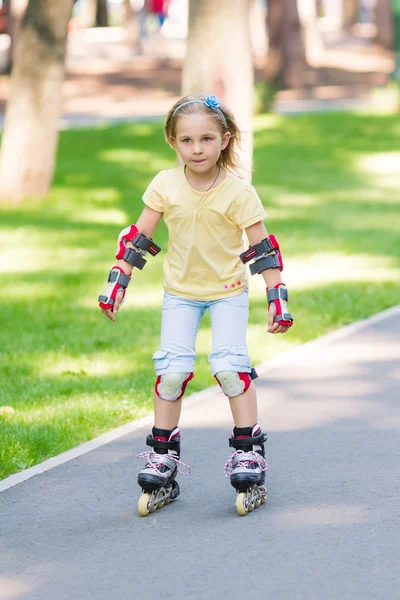 Little girl rollerskating in the park — Stock Photo, Image