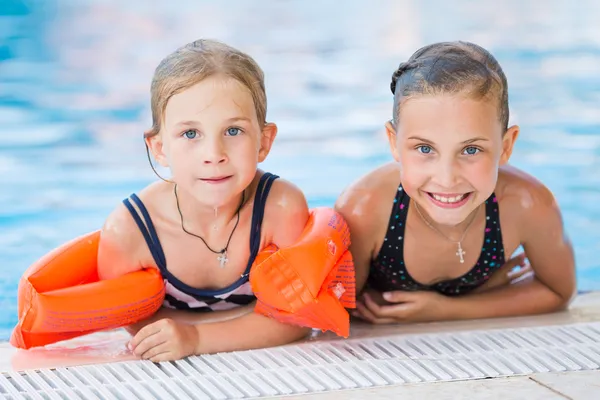 Two cute little girls in swimming pool — Stock Photo, Image