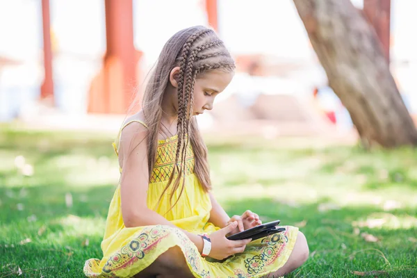 Симпатичная маленькая девочка учится с планшетным компьютером — стоковое фото