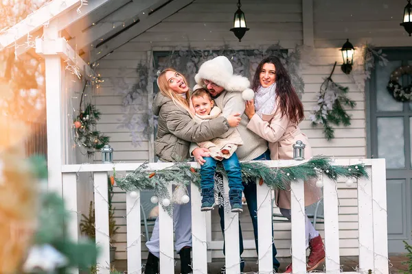 快乐的一家人在圣诞的门廊上装饰着房子 室外下雪 新年快乐 圣诞快乐 神奇的冬天 — 图库照片