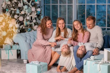 Büyük mutlu bir aile ve bir sürü çocuk Noel ağacının yanındaki kanepede eğleniyorlar. Noel arifesi, Noel ruh hali konsepti