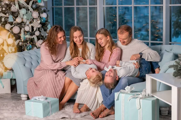 一个快乐的大家庭 有很多孩子在圣诞树旁的沙发上玩得很开心 圣诞节前夕 圣诞节气氛的概念 — 图库照片