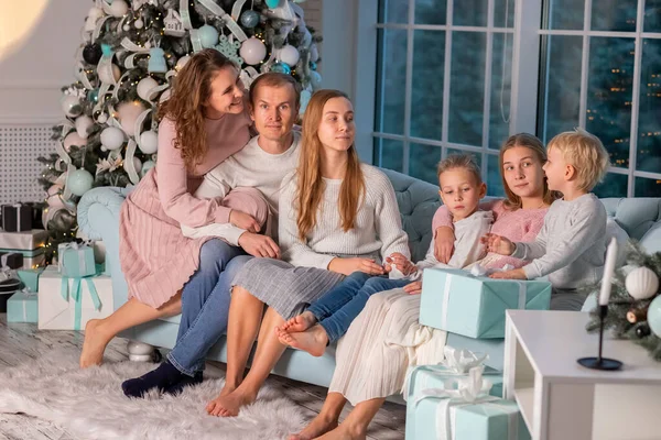 一个快乐的大家庭 有很多孩子在圣诞树旁的沙发上玩得很开心 圣诞节前夕 圣诞节气氛的概念 — 图库照片