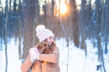 Küçük tatlı kız kartoplarıyla oynarken eğleniyor, kartopu atmaya hazır. Kar oyunları. Kış tatili.