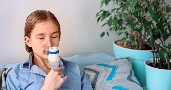 十几岁的女孩用雾化器设备吸入 生病的孩子手里拿着吸入器 通过家中的吸入器呼吸 流感和支气管哮喘的物理治疗 — 图库照片