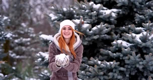 눈내리는 겨울날 속에서 밖에서 즐겁게 즐기고 소녀가 카메라에 스노우볼을 던지고 — 비디오
