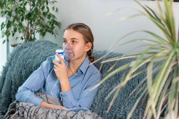 十几岁的女孩用雾化器设备吸入 生病的孩子手里拿着吸入器 通过家中的吸入器呼吸 流感和支气管哮喘的物理治疗 — 图库照片