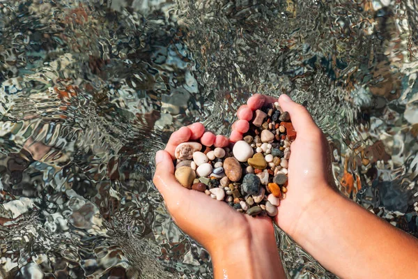 Hands Full Colorful Pebbles Forming Heart Shape Sea Waves Background — Stock Photo, Image