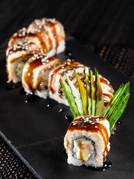 Sushi Roll Met Gerookte Paling Avocado Een Zwarte Steen Plaat — Stockfoto