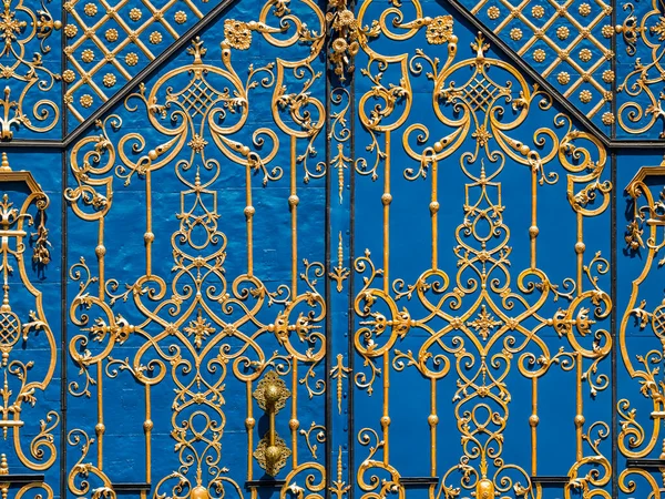 蓝色金属门的前视图 带有漂亮的弯曲的金色饰物 — 图库照片