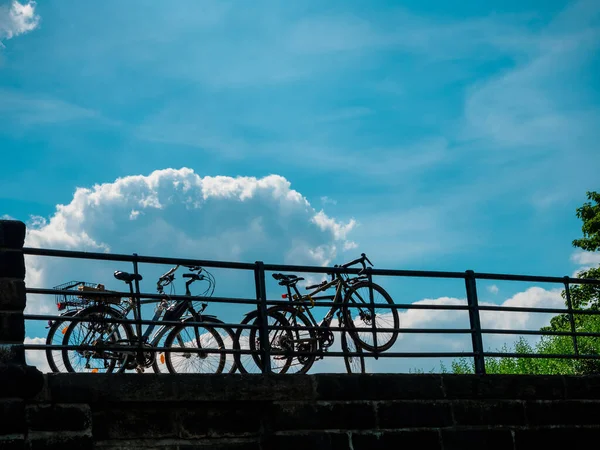 Cztery Rowery Zaparkowane Pobliżu Metalowego Ogrodzenia Tle Błękitnego Nieba — Zdjęcie stockowe