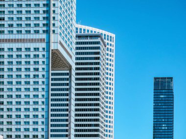 Mavi gökyüzü arkaplanı üzerinde modern beyaz gökdelenlerin ön görüntüsü