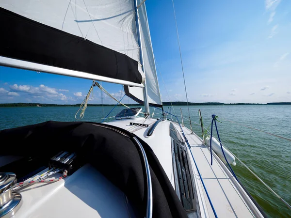 Güneşli bir günde yelkenli bir teknede yelken açılır ve açılır.