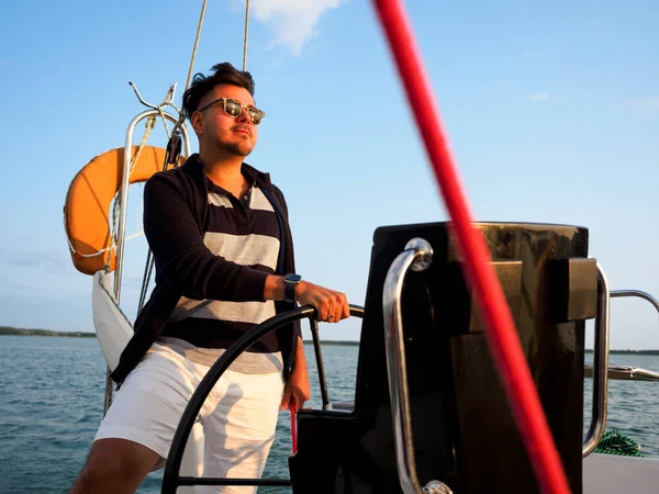 在度假时驾驶帆船或帆船的英俊黑头发人士 — 图库照片