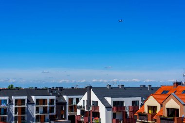 plane fly in the sky above a modern apartment house in a city residential district, modern living in a urban space
