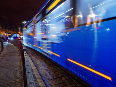 city tram departure from tram station in the night city. urban public transportation