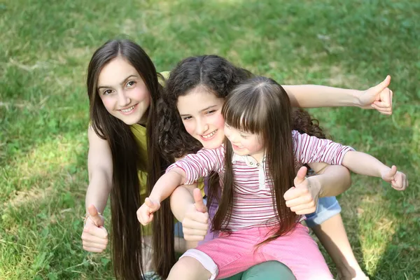 Mutlu kız parkta başparmak giving yukarıya. — Stok fotoğraf