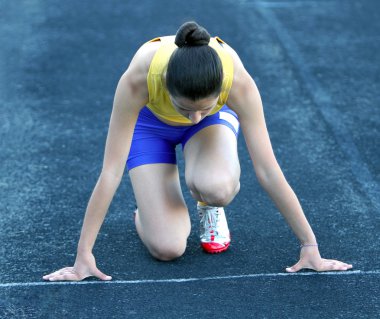 başlangıç konumu yolda atletik genç kız .