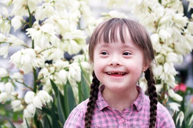 Portrait of beautiful young girl on flowers background. clipart