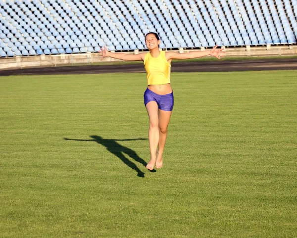 Bela adolescente esporte menina correndo na grama do estádio . — Fotografia de Stock