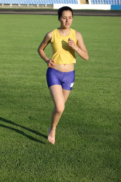 Bela adolescente esporte menina correndo na grama . — Fotografia de Stock