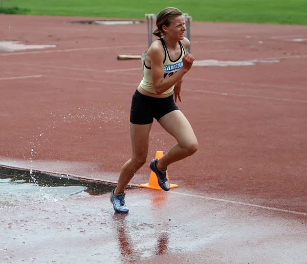 Menina competir no 3.000 metros Steeplechase — Fotografia de Stock
