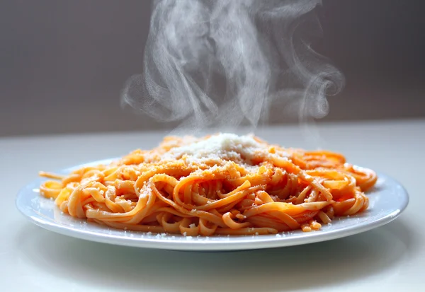 Italian spaghetti steaming with parmesan cheese. — Stock Photo, Image