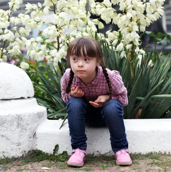 Menina bonita situada no fundo flores — Fotografia de Stock