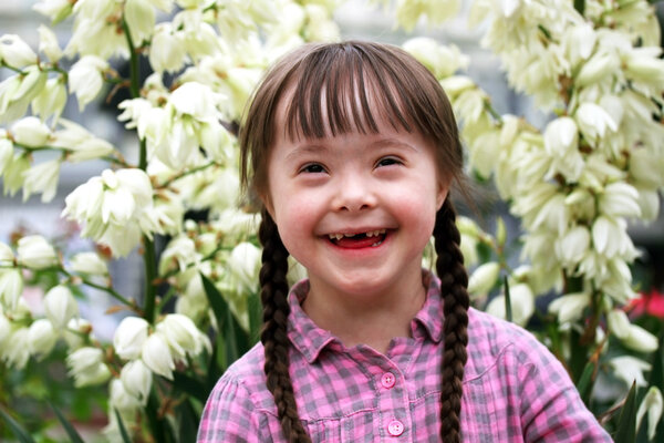 Portrait of young happy girl on flowers background.