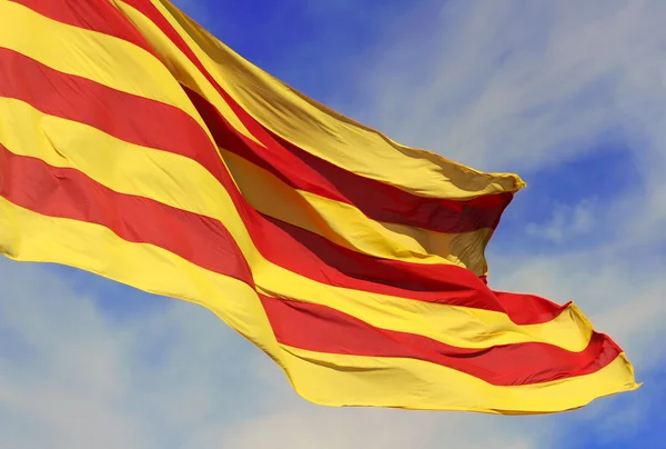 Waving flag of the Catalunya (Catalonia) on background of the blue sky. — Stock Photo, Image