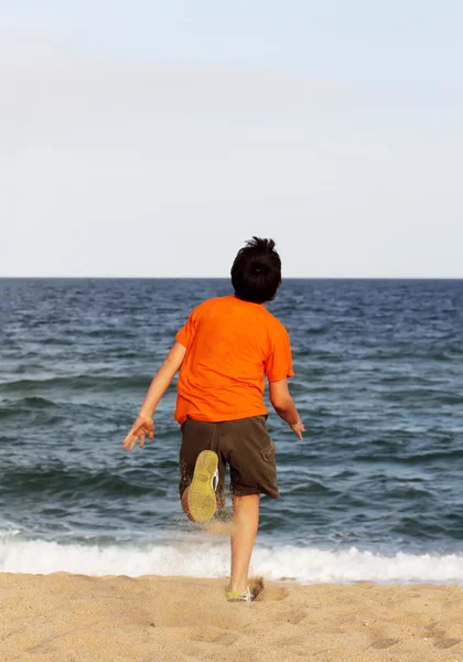 Menino correndo para o mar em férias de verão — Fotografia de Stock