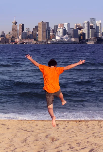 Chłopiec skacze do vancouver z plaży north vancouver — Zdjęcie stockowe