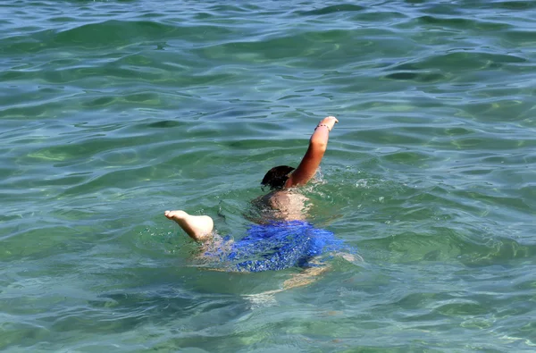 Garçon actif nageant dans l'eau de mer . — Photo