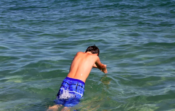 Actieve jongen zwemmen in het zeewater. — Stockfoto