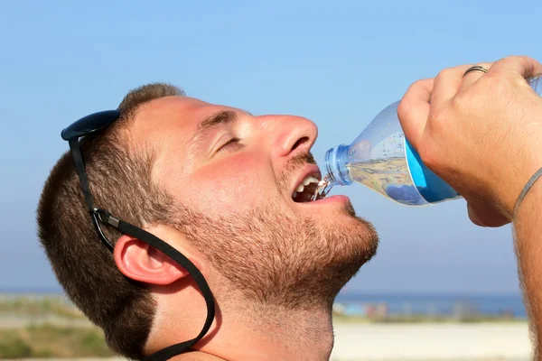 A man thirsty eagerly drinking water from plastic bottle — Stock Photo, Image