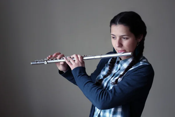 Teenage girl plays the flute. — Stock Photo, Image