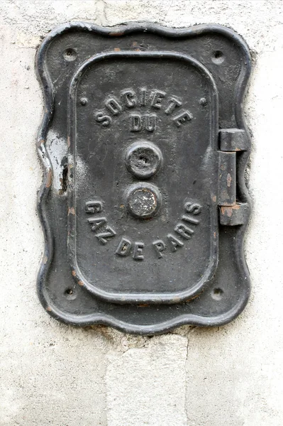Uma placa de ferro velha em uma parede em Paris . — Fotografia de Stock