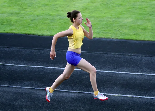 Menina correndo na pista do estádio — Fotografia de Stock